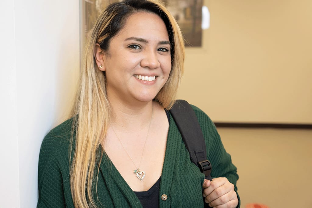 Felician nursing student standing by wall