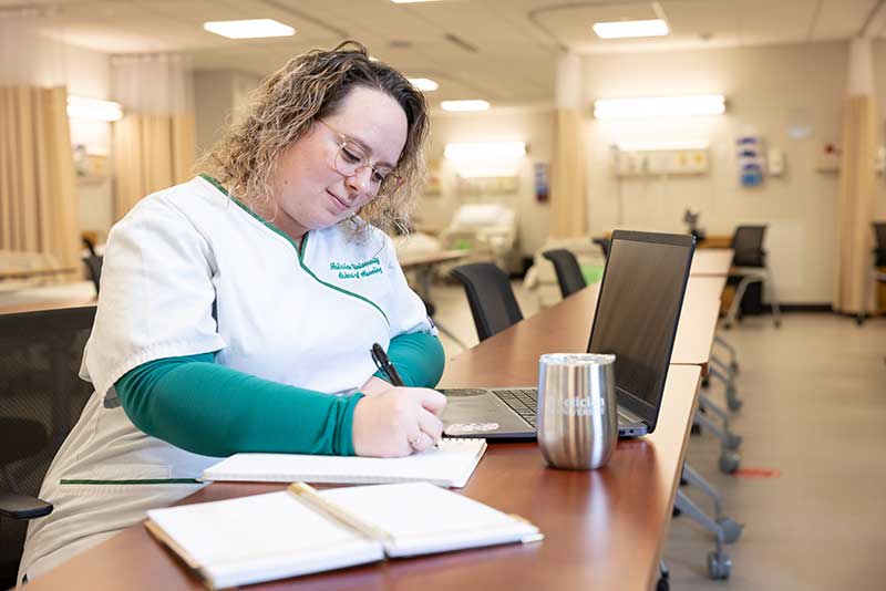 nursing student sitting at desk studying