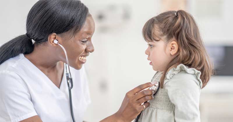 Nurse listening to child patient's heartbeat