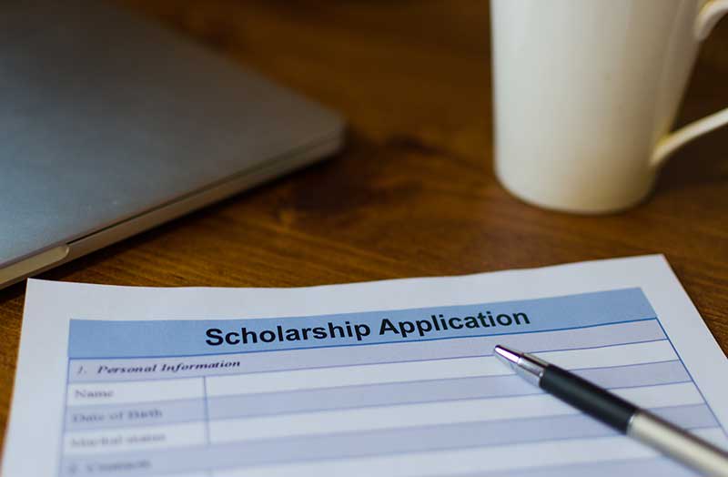 scholarship application on desk with a pen