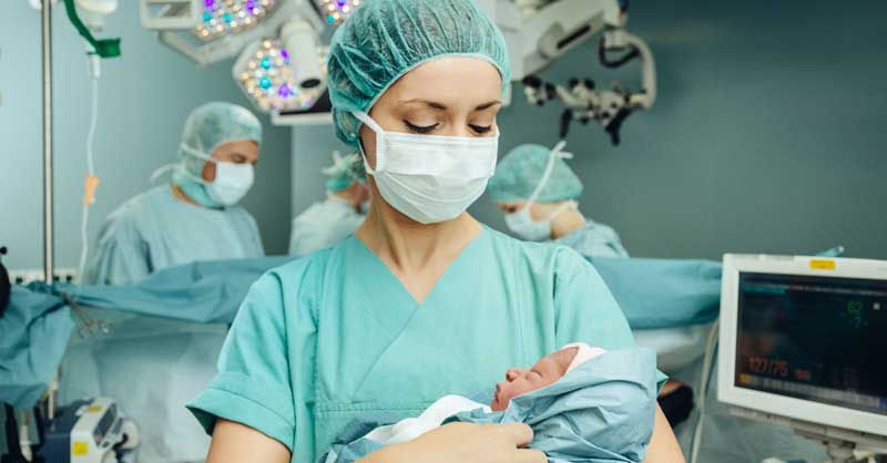 nurse in NICU holding baby