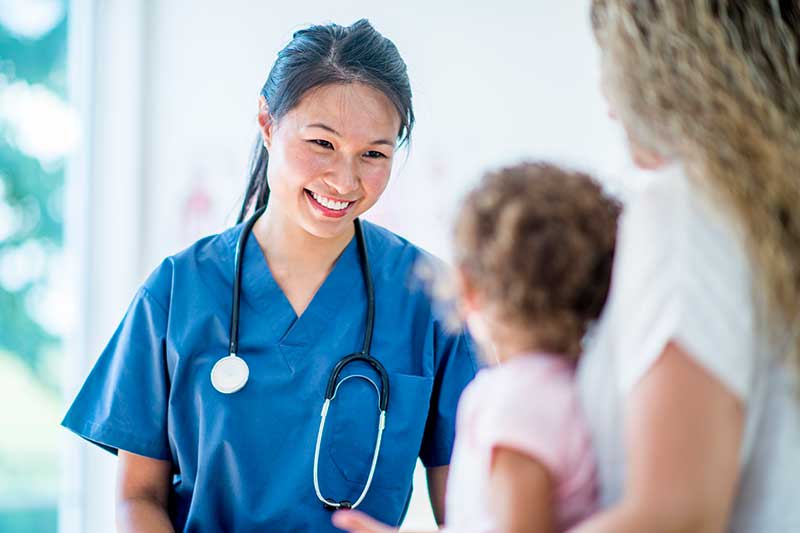 nurse smiling at young child patient