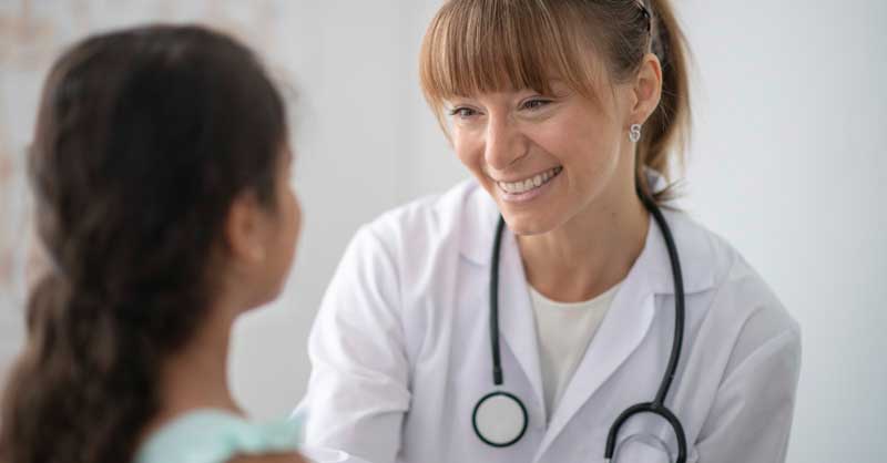 smiling nurse looking at child patient