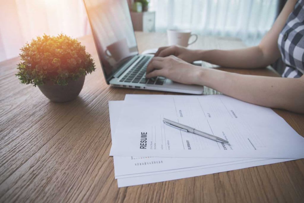 person sitting at desk typing on laptop