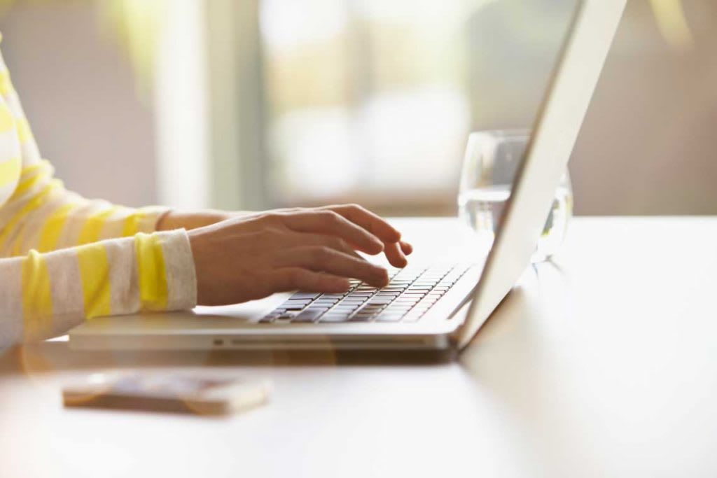 hands typing on a laptop