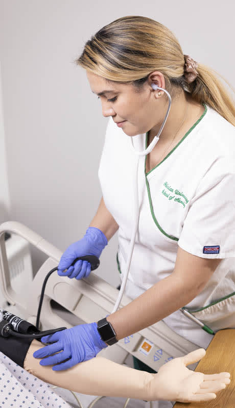 Nurse with blood pressure cuff on mannequin