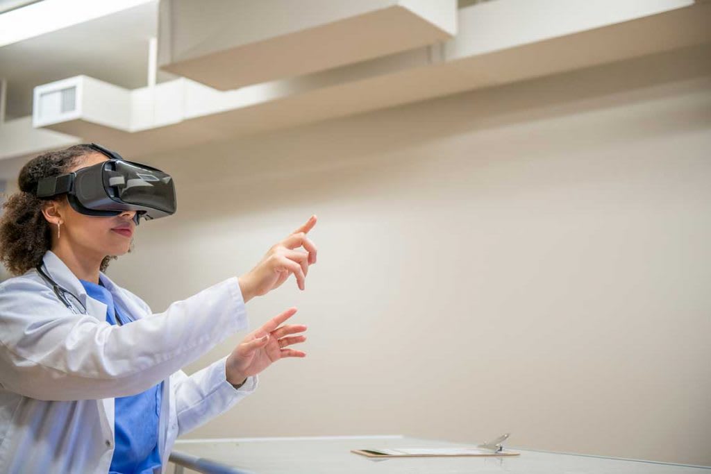 nurse wearing a VR headset reaching out in front of her