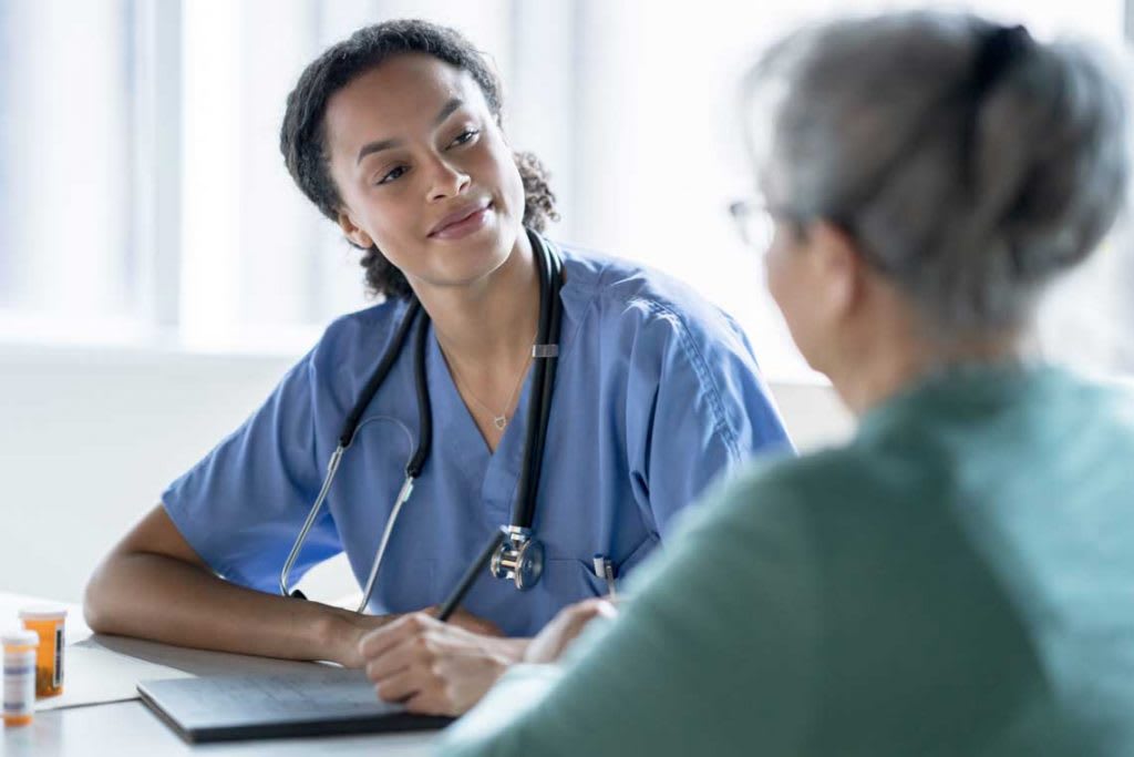 nurse sits with patient