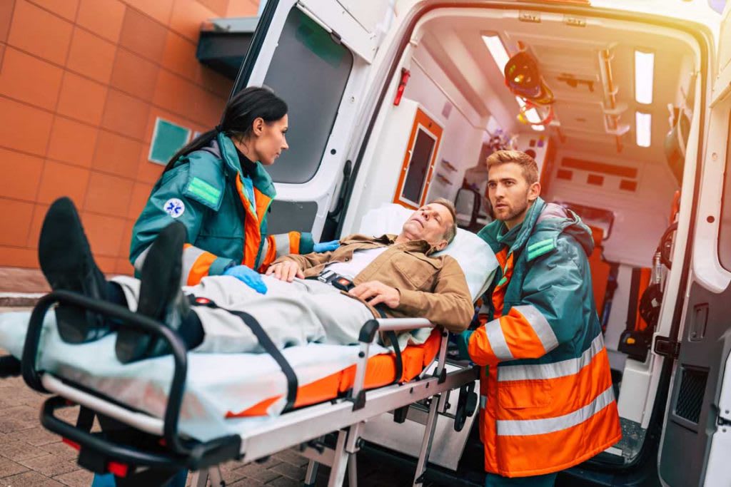 EMTs with patient in front of ambulance