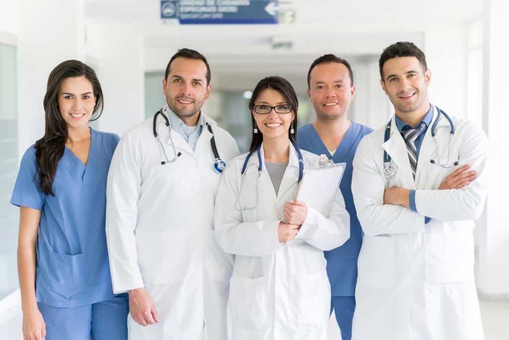 several nurses standing in row smiling at camera