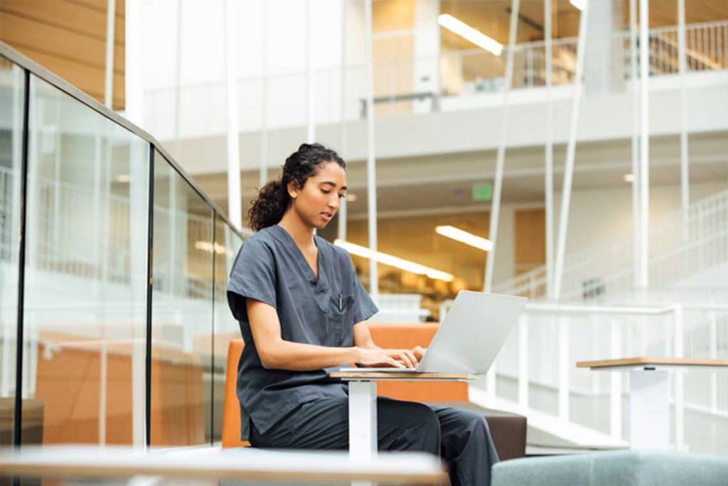 nursing student sitting and using laptop