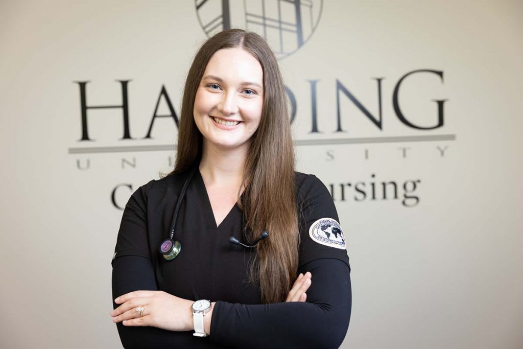 nursing student in front of sign