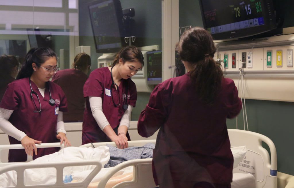 Loyola students working together in clinical setting