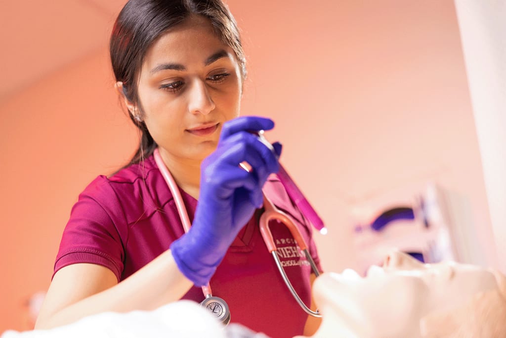 Loyola nursing student shining light into manikin's mouth