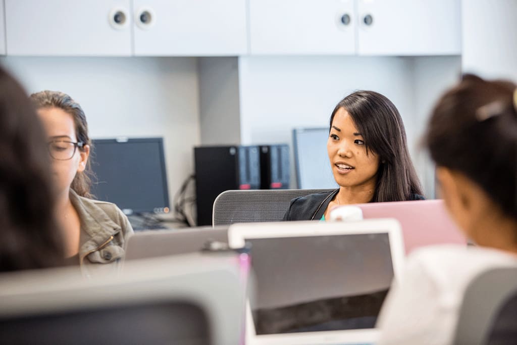 Students with laptops in a professional setting