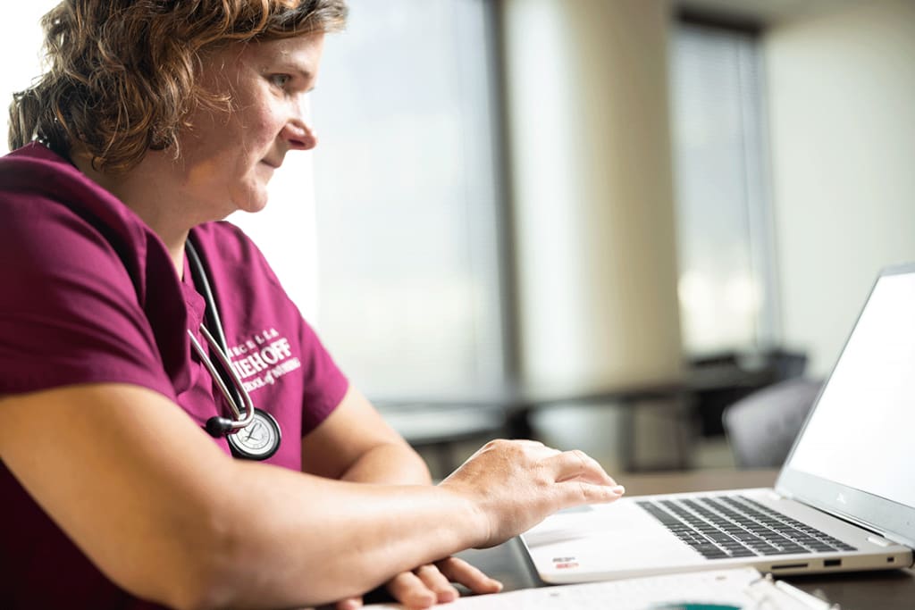 Loyola nursing student on laptop