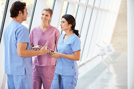 three nurses in a hospital hallways