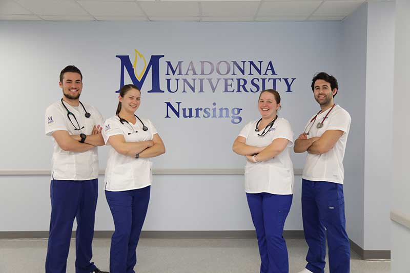 Four nursing students standing in front of wall