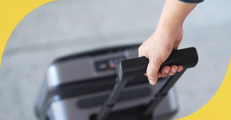 person pulling a rolling luggage bag