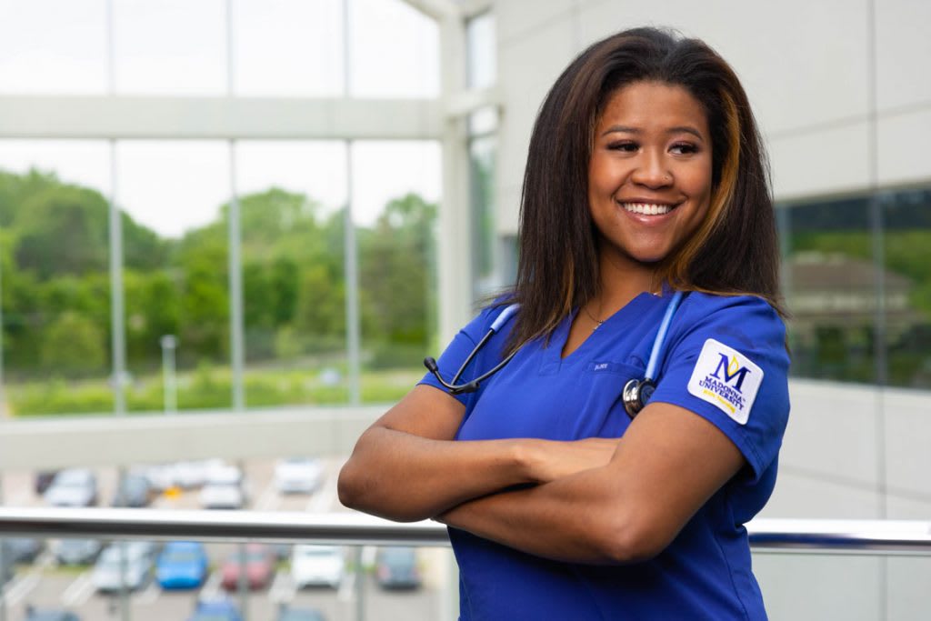 Madonna nursing student smiling with arms crossed