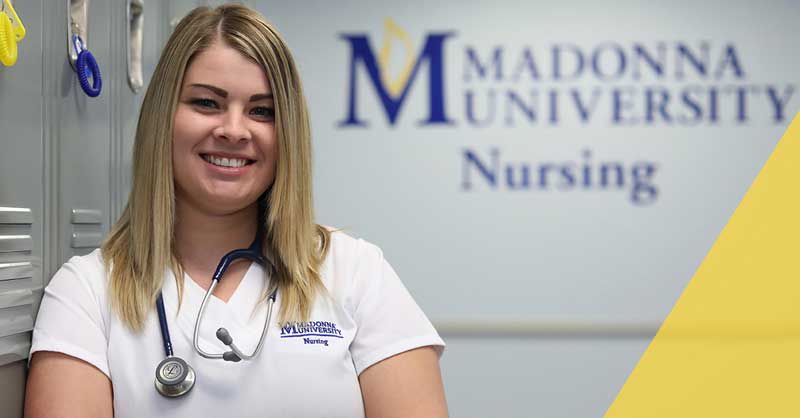 Madonna ABSN student standing by lockers