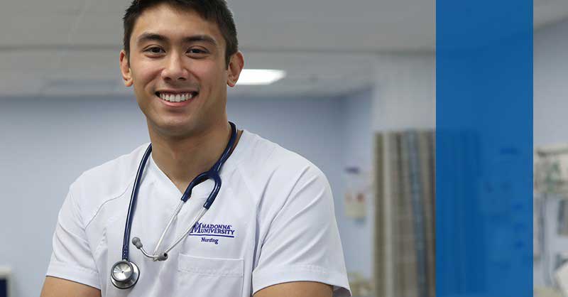 Madonna ABSN student smiling, standing in lab