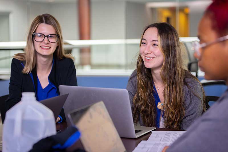 three Madonna ABSN students using laptop computers