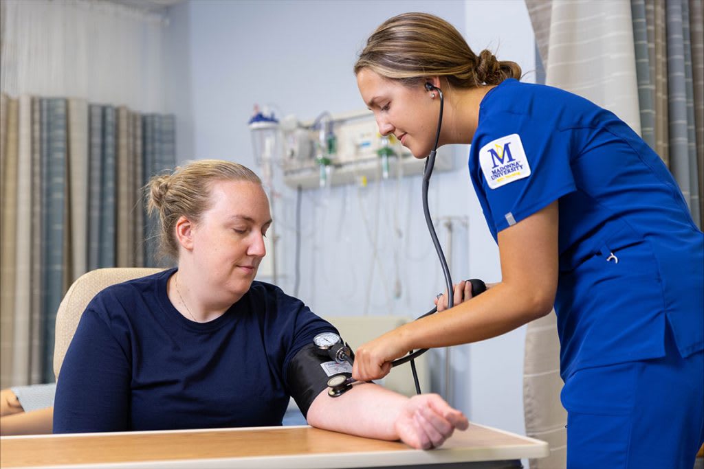 Madonna ABSN student using stethoscope on patient