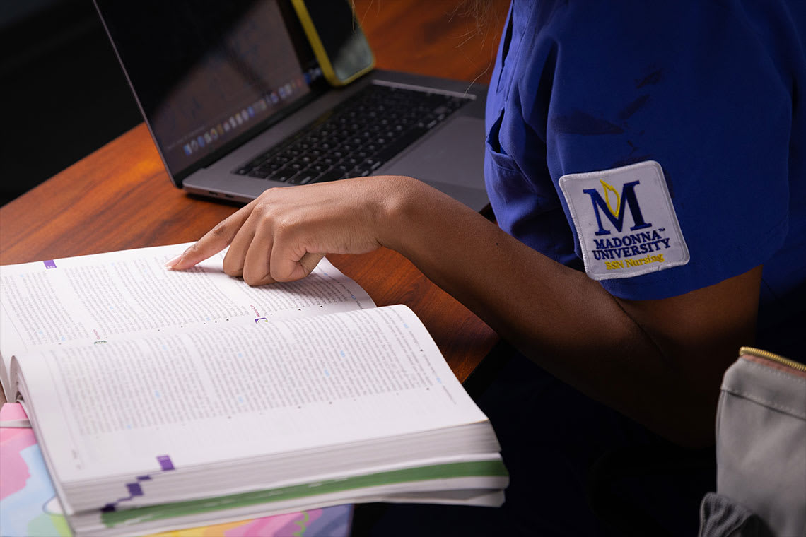 Madonna nursing student reading a textbook