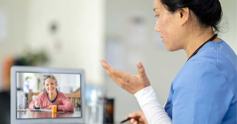 Nurse speaking virtually to patient on tablet