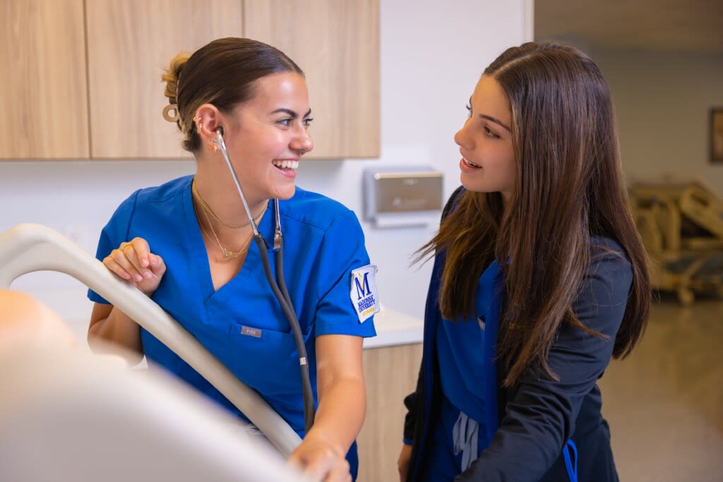 two Madonna nursing students in sim lab