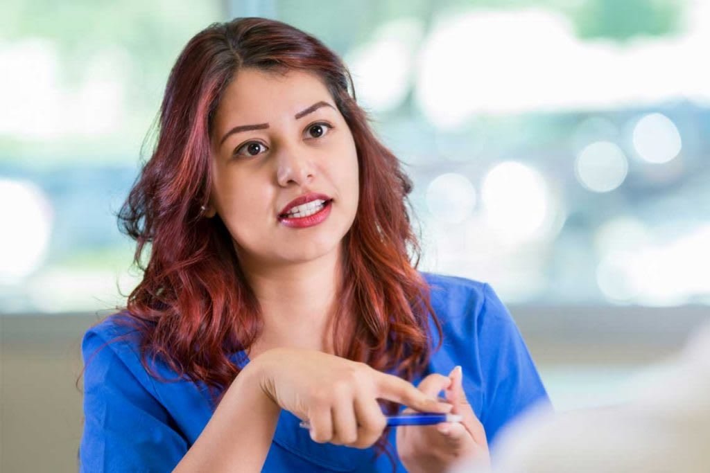 nurse sitting at desk talking in interview