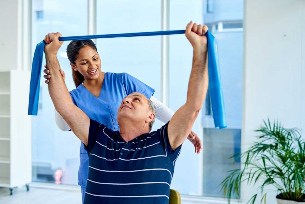 nurse helping older patient with a stretch band