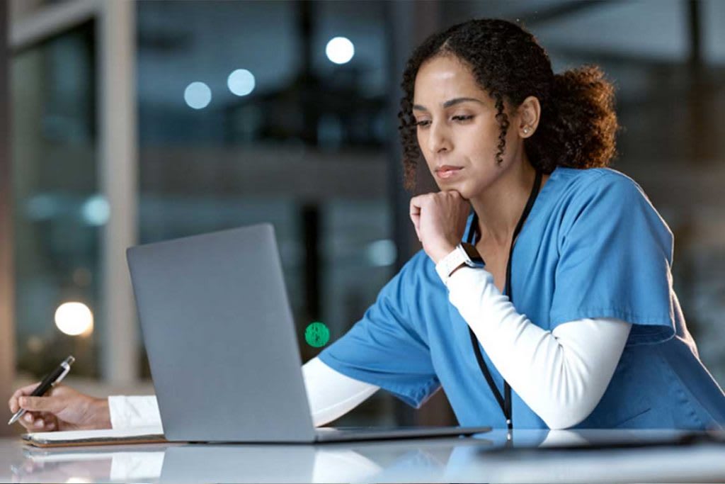 nurse sitting at table using laptop