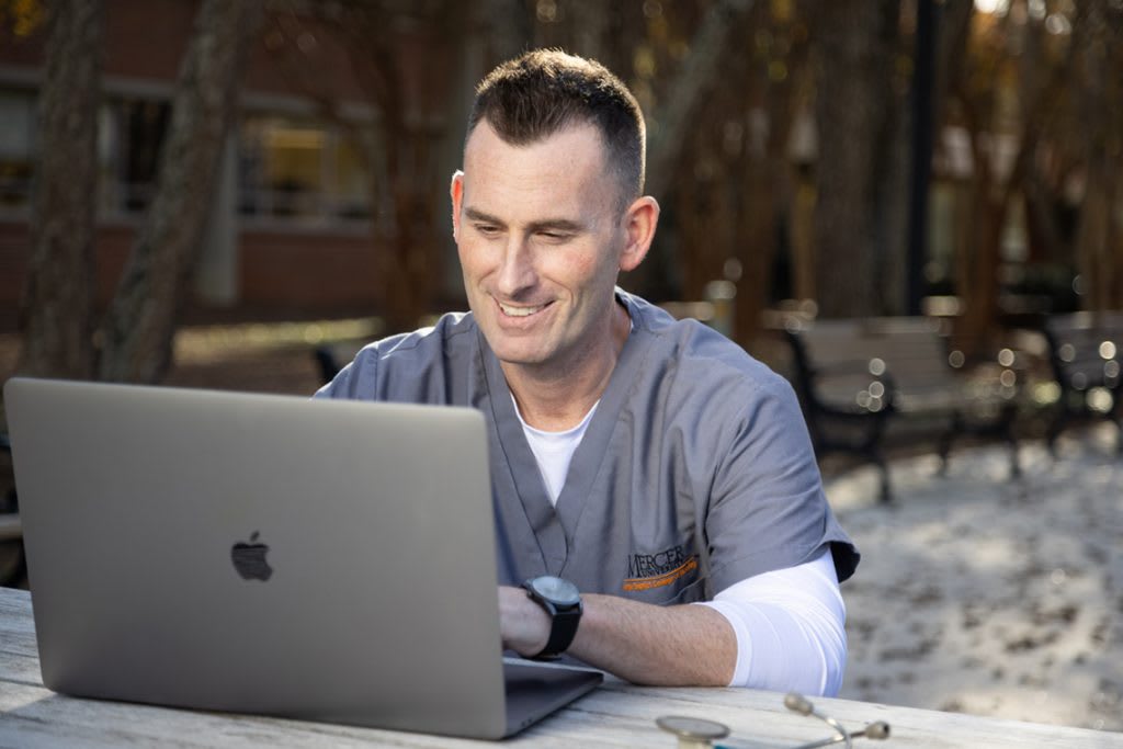 Mercer ABSN student outside using laptop
