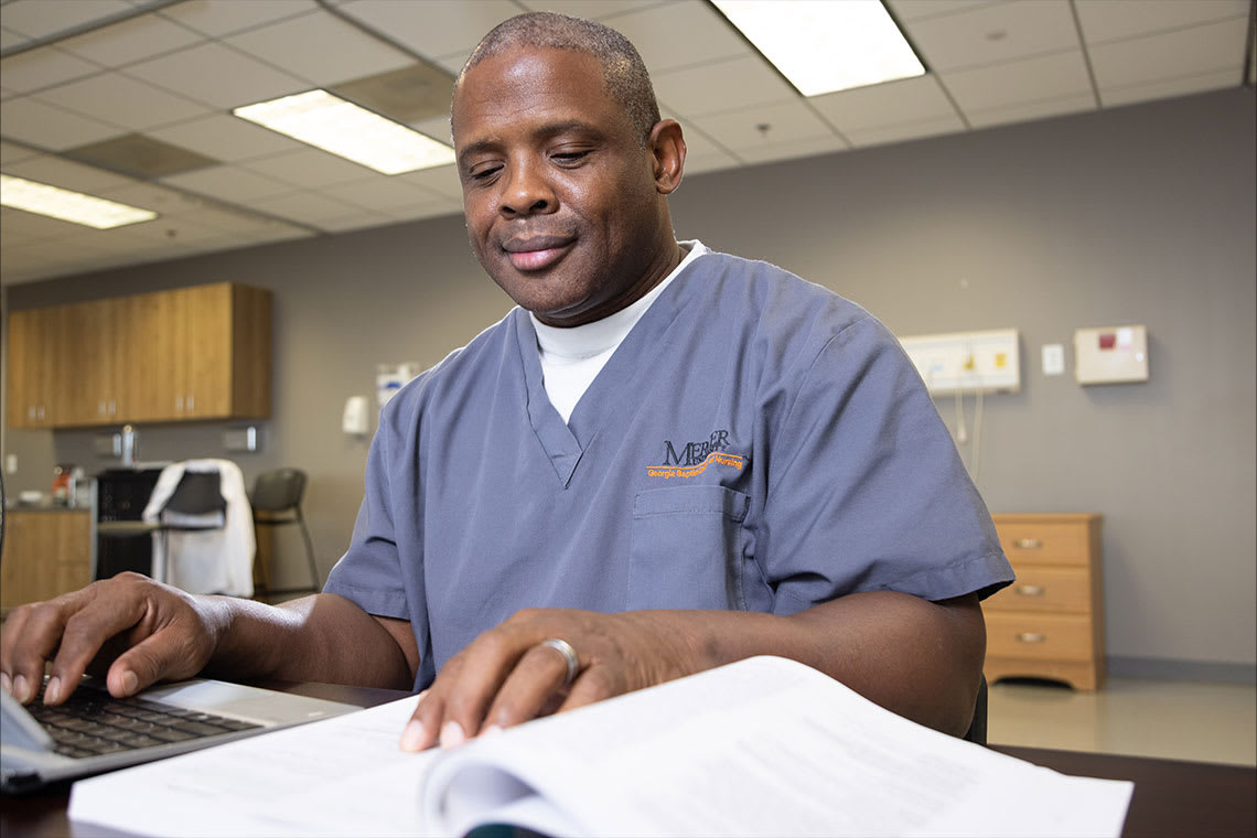 Mercer nursing student sitting at desk reading textbook