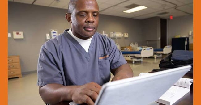 nursing student sitting at desk using laptop