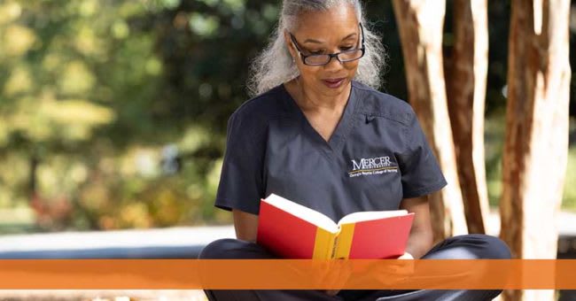 woman sitting outside reading a book