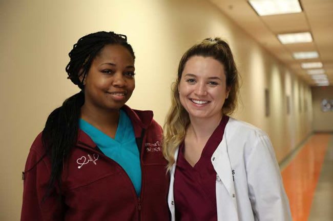 two Mercer ABSN students smiling in hallway