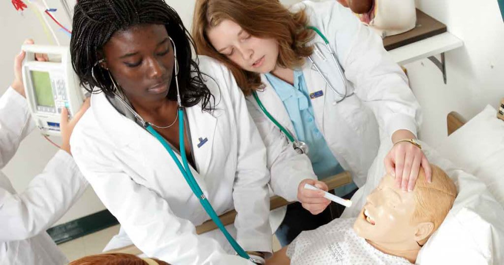 nursing students working with simulation manikin