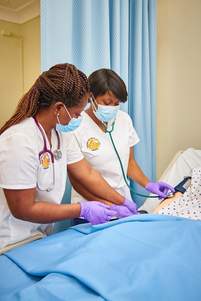 Nursing students practicing on manikin