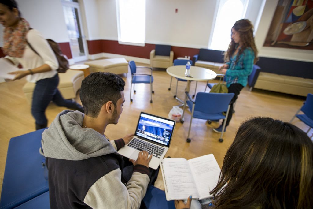 students in class looking over notes and computers