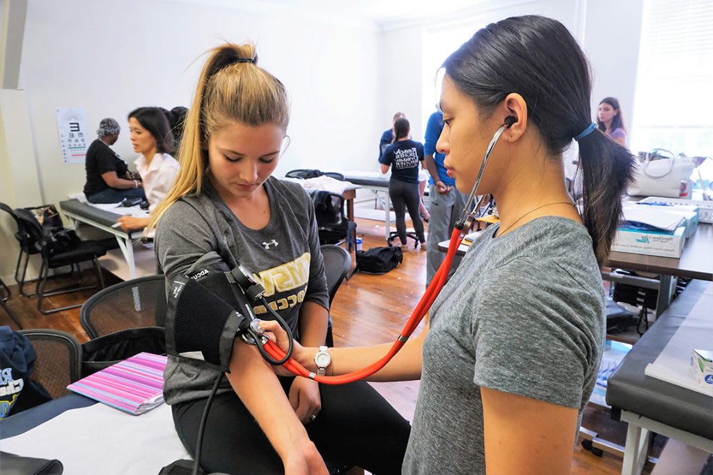 Nursing students practicing using a stethoscope
