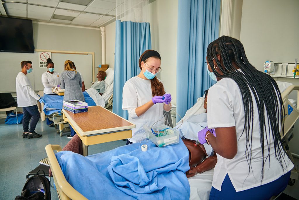 Nursing students practicing on a manikin