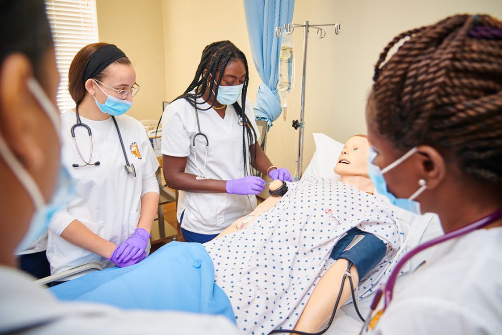 Nursing students practicing on a manikin