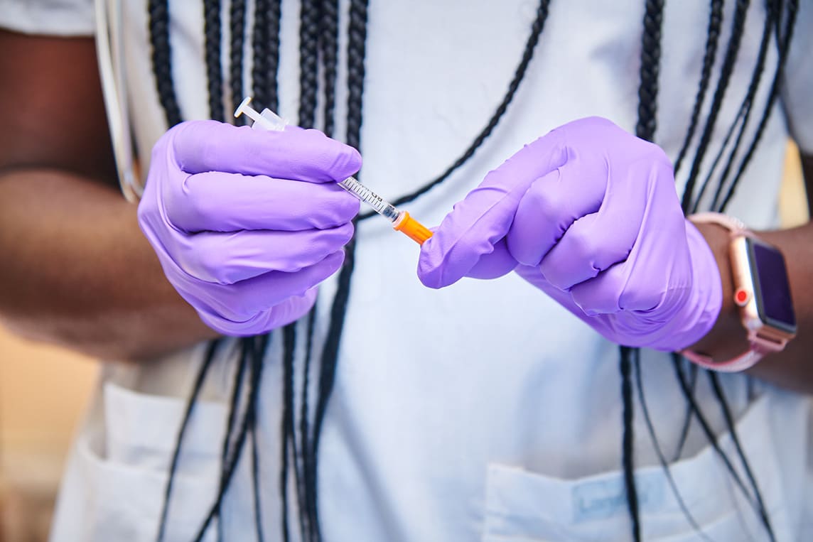 close up of nurse's hands in purple gloves