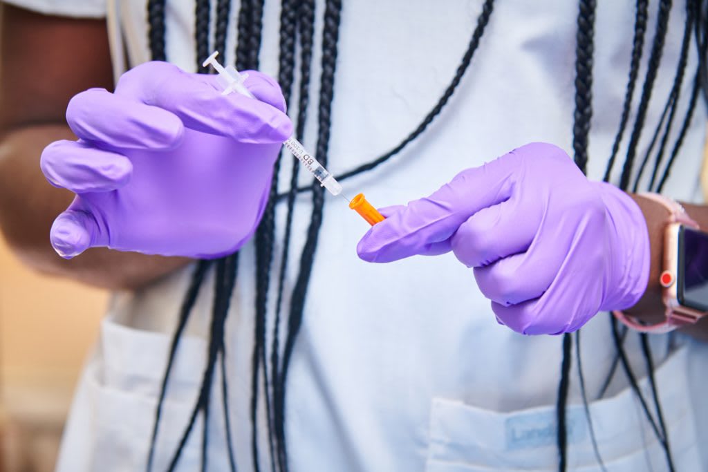 close up of nurse's hands in purple gloves