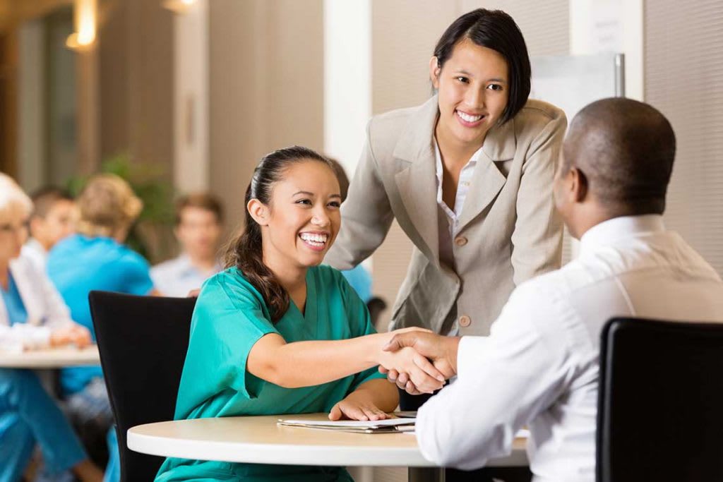 nurse shaking a man's hand in interview