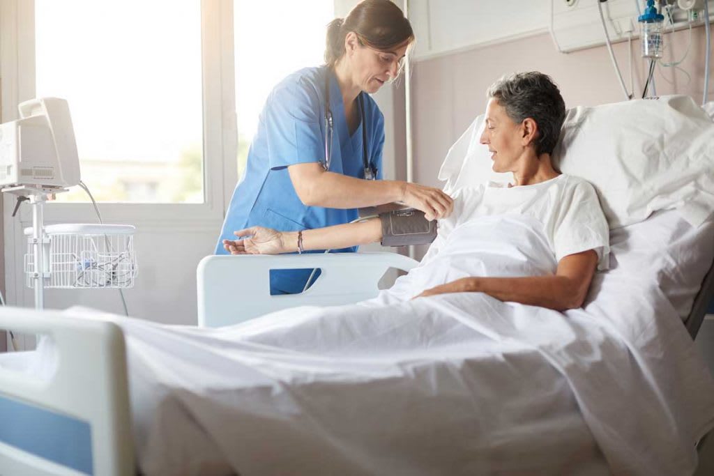 nurse checks patient's blood pressure