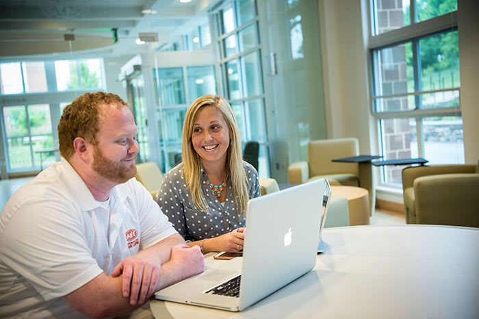 two people meeting at table with laptop